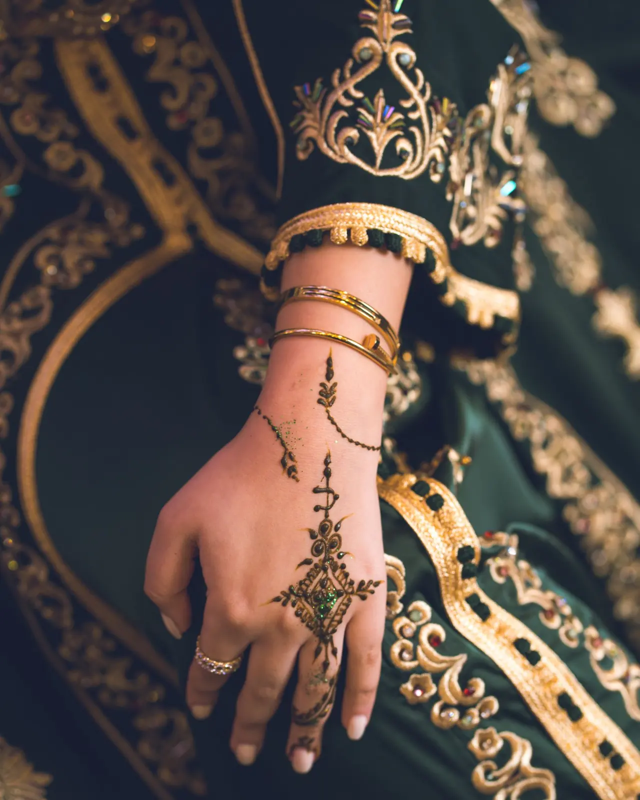 Henna patterns, gold bracelets, and embroidery on a Moroccan bridal sleeve